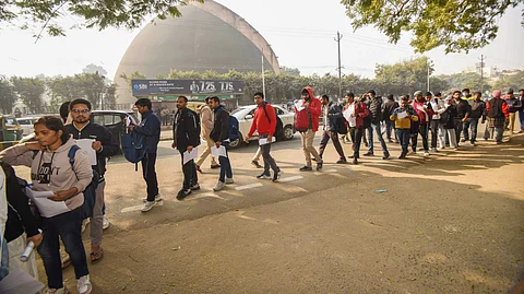 Applicants wait in a queue outside an exam center before appearing for BPSC Prelims exam 2024