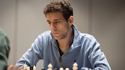 This undated photo released by Charlotte Chess Center shows Daniel Naroditsky playing chess on the board.