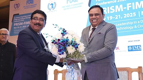Dr S Verma presenting a bouquet of flower to Dr TG Sitharam