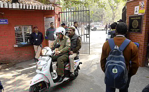 Delhi police personnel, college staff and students at Ramjas college in Delhi University after receiving bomb threat emails in New Delhi on Wednesday.