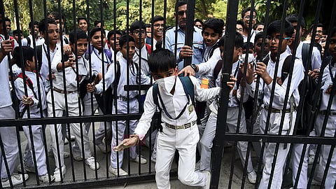 Students leaves wearing mask after school reopens after Smog Vacation in Delhi on Wednesday.