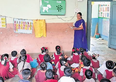 A teacher uses an internet-enabled television to teach students at an MPPS in Janakapur of Asifabad mandal in Komaram Bheem Asifabad district
