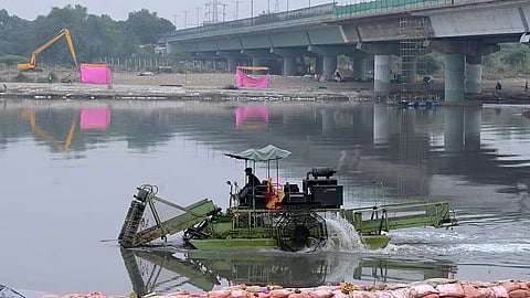 Workers clean Vasudev Ghat Yamuna river a day after Chhath puja in New Delhi