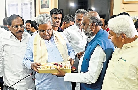 Former minister H Anjaneya distributes sweets to CM Siddaramaiah and ministers after the cabinet decided to implement 15% internal quota for Scheduled Castes, at Vidhana Soudha in Bengaluru on Friday