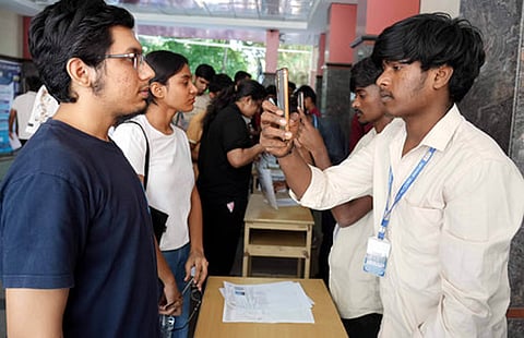 In this image from April 23, 2026, students appearing for the CET exam are being screened at a private college in Bengaluru.