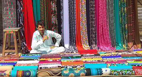 A clothing vendor in Karachi’s Old City selling all sorts of colorful prints. Pic: Bilal Hassan/Everyday Pakistan