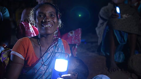 Woman with the solar light distributed by Think Peace