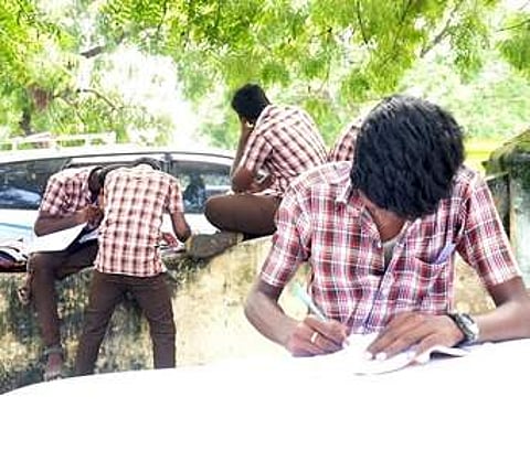 Students writing Thirukkural couplets