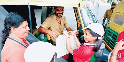Students of Little Flower UP School, along with their teacher, selling cloth bags to autorickshaw drivers