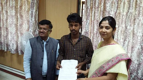 C Shikha, Director, Department of Pre-University Education congratulate Dhananjaya for his results in PUC II exams