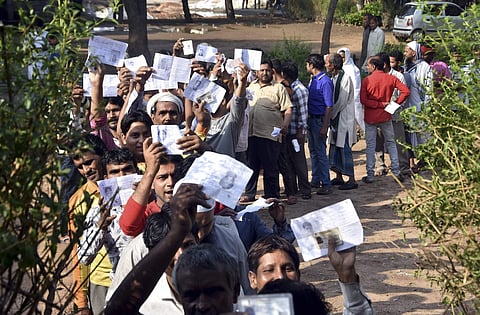 Mathura Voters show their identity cards as they stand in a queue at a polling station to cast vote during the second phase of the general elections in Mathura on Thursday (Pic: Pic)