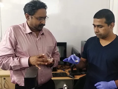 Prof Renu John with a colleague who is holding the device