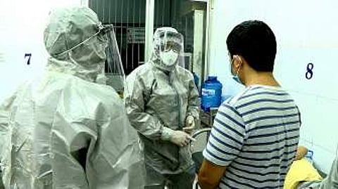 Medical personnel wearing protectice suits interact with two patients tested positive to the coronavirus (Pic: AFP)