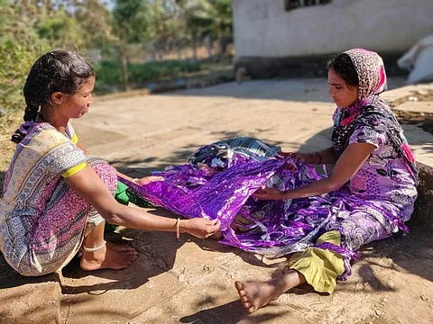 Women sorting out the plastic and gift wrapper collected from waste pickers