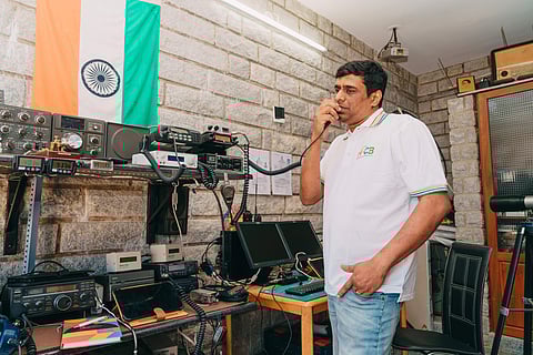 Madhu Prasad operating a wireless radio to communicate with people