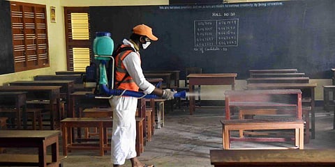 A sanitation worker spraying a classroom| Representative Image