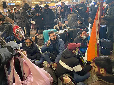 Indian students stranded in Ukraine sit at a railway station after being denied permission to board trains by local police (Pic: PTI)