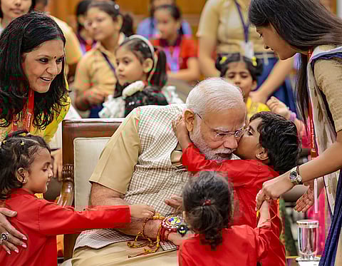 School students tie 'rakhi' to Prime Minister Narendra Modi on the occasion of 'Raksha Bandhan', in New Delhi, Wednesday, Aug. 30, 2023. (PTI Photo)