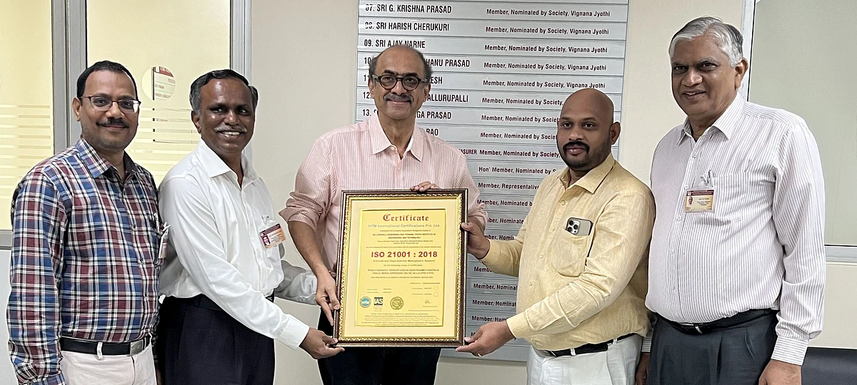 Suresh Babu receiving the ISO certificate, along with Principal, Director for Advancement, and Coordinator 