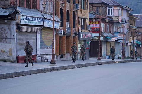 Security officers patrol a shopping area in Pahalgam