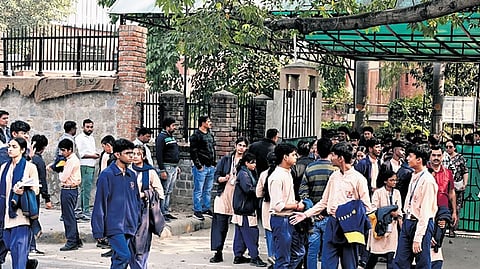People empty the premises after a bomb threat received at Sanskriti School at Chanakyapuri, in New Delhi on Thursday.