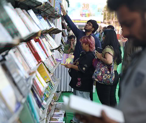 Visitors browse through stacks of books at a stall during the Hyderabad Book Fair at NTR Grounds in Hyderabad on Friday. 
