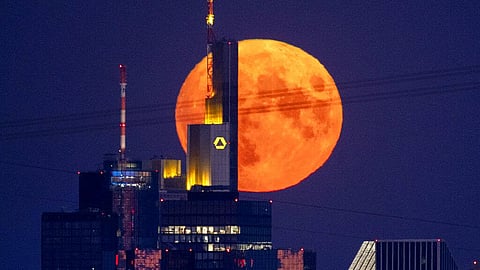 The full moon rises behind the buildings of the banking district in Frankfurt, Germany. 