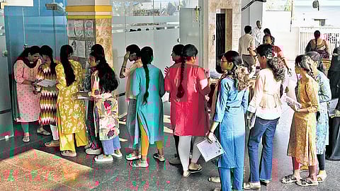 On the first day of the Intermediate Public Examinations in Telangana, first-year students wait in a queue and check their details 