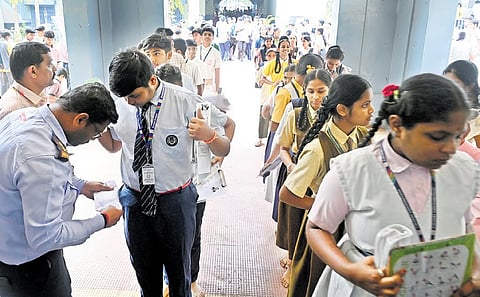 Students being checked before they enter an SSLC exam centre in Bengaluru on Wednesday.