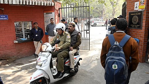 Delhi police personnel, college staff and students at Ramjas college in Delhi University after receiving bomb threat emails in New Delhi on Wednesday. 