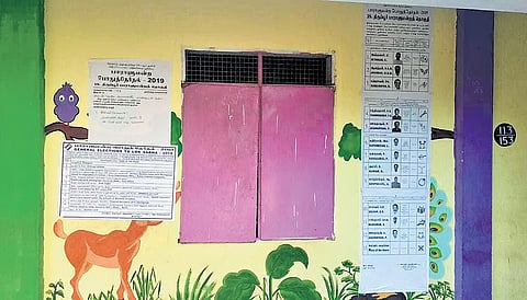 Election related notices pasted on the wall with paintings at a govt school 
