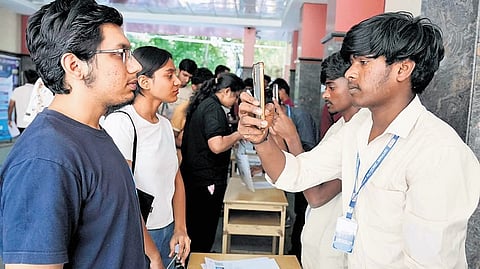 Students appearing for CET get scanned before entering the exam hall at the PU College in Seshadripuram on Thursday.