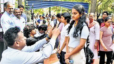 Higher Education Minister MC Sudhakar scans students who arrived for CET at a college in Bengaluru on Friday 