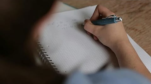 Image of a student writing an exam used for representational purposes only