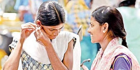 A girl student removing her ear studs before appearing for NEET exam in Hyderabad on Sunday | R Satish Babu