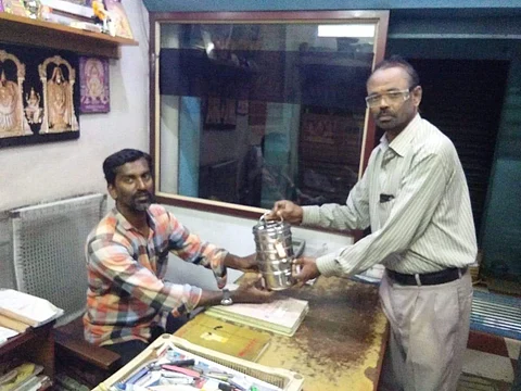 Volunteer of Nesakaram Dabbawala delivering home-cooked food to a customer (Pic: Nesakaram)