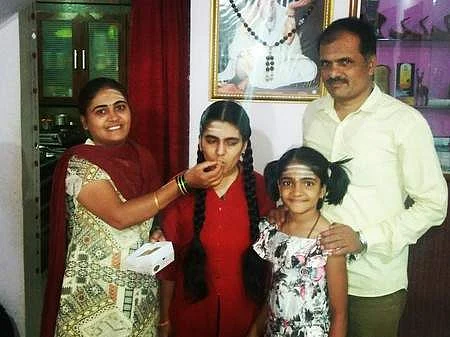 Basamma with her parents and sister celebrating her success by feeding sweets