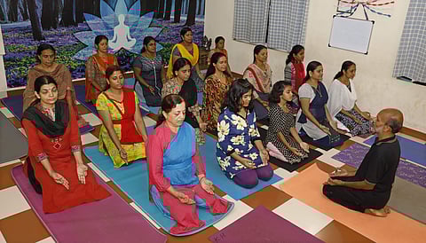 Vinod V P performing yoga asanas with his students at Soorya Bhavana Yoga Therapy Centre, Pirayiri, Palakkad