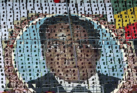 Zimbabwean children hold cards that make up a portrait of Robert Mugabe during the 25th anniversary of independence celebrations in 2005 (Pic: Howard Burditt/Reuters)