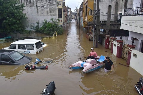 Hyderabad: Buildings and vehicles lie partially submerged in floodwater following heavy rains, at Falaknuma, in Hyderabad, Wednesday (Pic: PTI)
