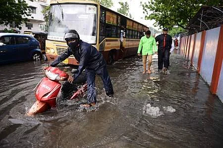 A man pushes his scooter on a flooded road near Egmore after heavy rainfall ahead of cylone Nivar landfall in Chennai | Pic: EPS