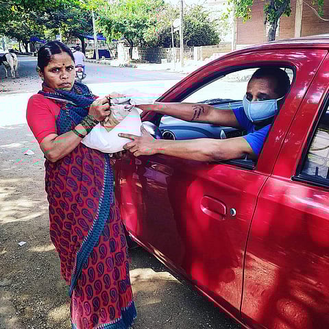 Srikanth V S giving grocery items to one of the migrant workers