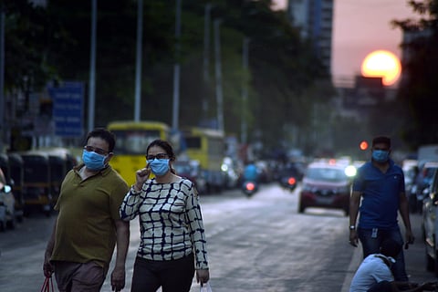 People wear masks, walk on a street during a nationwide lockdown| PTI