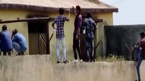 People seen climbing the boundary walls and providing chits to students (Pic:ANI)