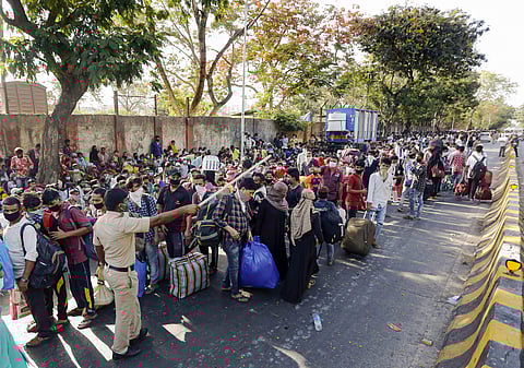 Migrants wait outside Mumbai's Chhatrapati Shivaji Terminus for a special train (Pic: PTI)