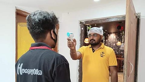 The delivery executive's temperature is checked by the restaurant staff as an extra precautionary step | (Pic: Hungrytin)