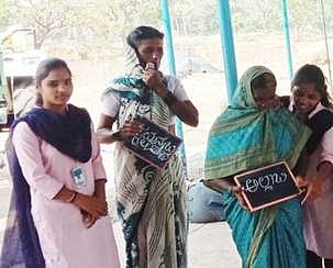 Government college students teaching villagers to write their names in slates (Pic: Express)