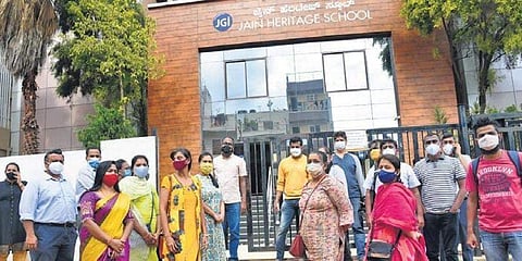 Parents gather outside Jain Heritage School in Bengaluru on Monday (Pic: Express)