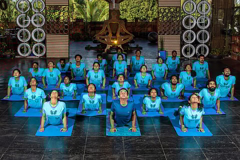 Yoga pupils practising along with the trainer