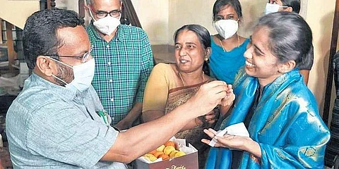 Revenue Minister K Rajan presents sweets to K Meera, who secured the sixth rank, at her residence in Thrissur on Friday | Pic: Express